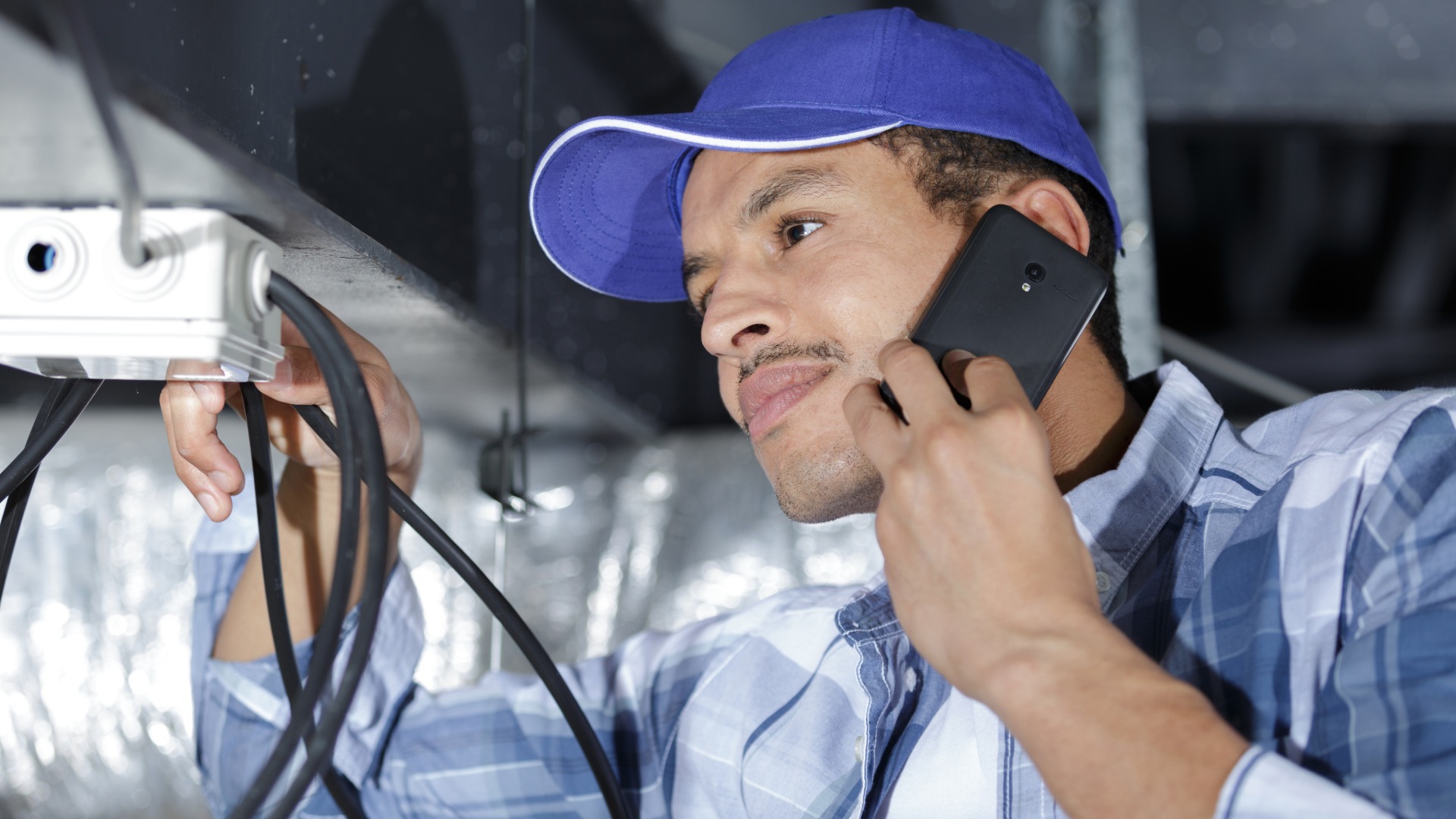 Electrician taking a service call by phone